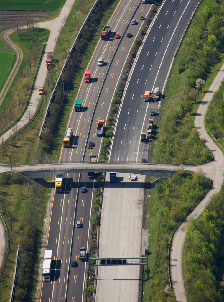 Mehrspurige deutsche Autobahn mit fließendem Verkehr aus der Vogelperspektive